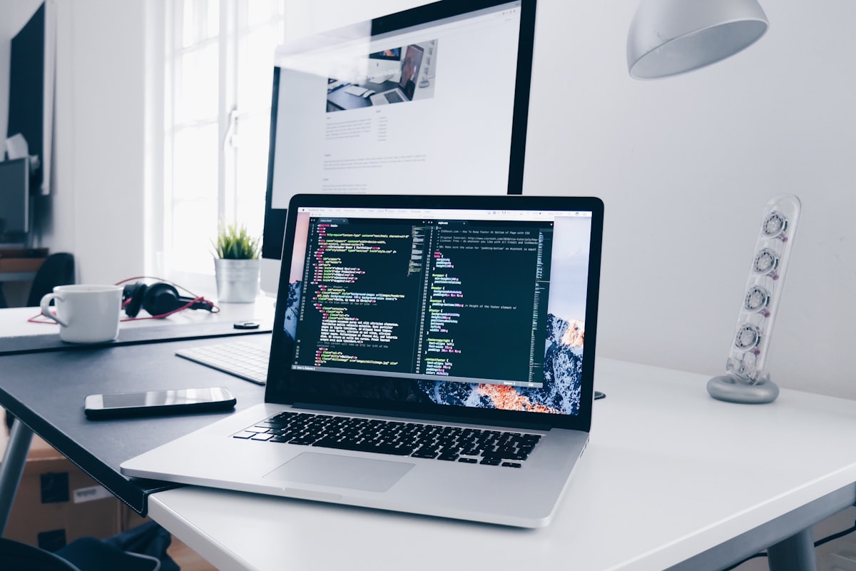 Poste de travail du studio : ordinateur portable affichant du code devant un second écran